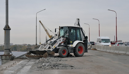 Tractor or excavator repairs bridge, removes garbage