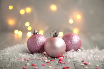 Three christmas ball in a snow on a wooden background. Holiday concept