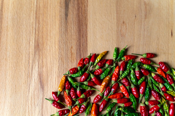 Colorful Chilli Peppers On Wooden Table. High Angle View