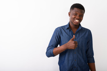 Studio shot of young happy black African man smiling while givin