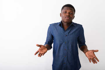 Studio shot of young black African man looking confused against 