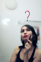 Inscription lipstick on mirror and reflection of a girl