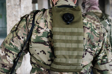 A soldier hydration pack a type of hydration system built as a backpack or waistpack, Sniper tripod