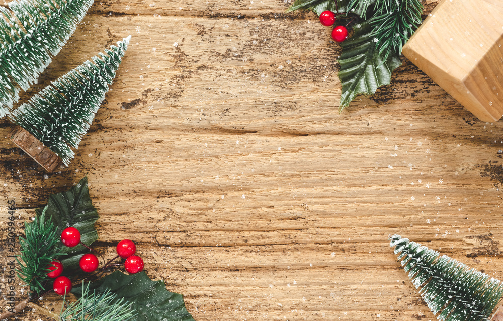 Poster top view of mini christmas tree and red burry leaf with wood home toy on rustic wooden table with sn