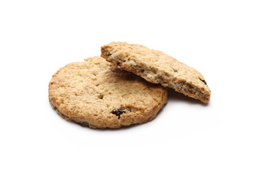 Round cracked wholewheat biscuit, cookie with raisins and crumbs isolated on white background