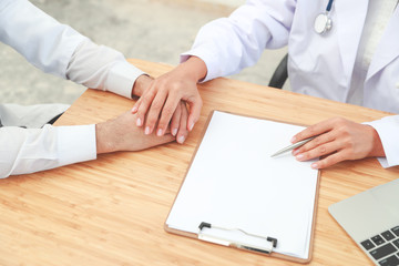 doctor comforting and holding hand male patient with care (medical concept)