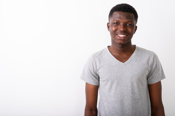 Studio shot of young happy black African man smiling against whi