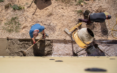 Workers pour concrete solution at a construction site
