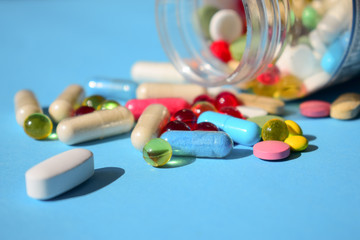 Medicines banned, pills recall. Multicolored bright various type pills and capsules spilling out of...