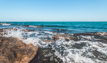 The wave breaks on the rock