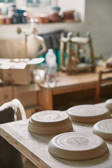 selective focus of plates at table in pottery studio