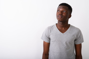 Studio shot of young black African man thinking while looking up