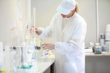 Female lab worker doing tests in a laboratory in an industrial cheese production factory