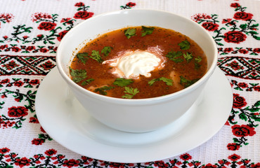 Ukrainian borsch on white background. red soup with beets  with sour cream on a Ukrainian towel