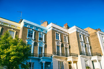 Fototapeta premium Classic row of terrace houses built from traditional yellow London stock brick lit by bright summer sun under bright blue sky