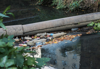 cleaning plastic and garbage in the river. ecological problems. plastic bottles and bags