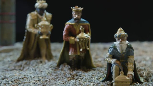 Closeup of the three kings with their gifts adoring the Child Jesus. Nativity scene figurines. Christmas traditions.