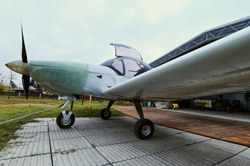 Fototapeta na wymiar Light single-engine aircraft in the summer before the storage hangar.