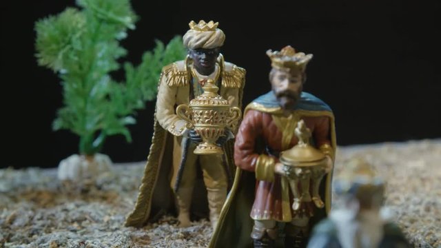 Closeup of the three kings with their gifts adoring the Child Jesus. Nativity scene figurines. Christmas traditions.
