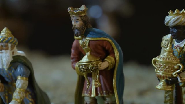 Closeup of the three kings with their gifts adoring the Child Jesus. Nativity scene figurines. Christmas traditions.