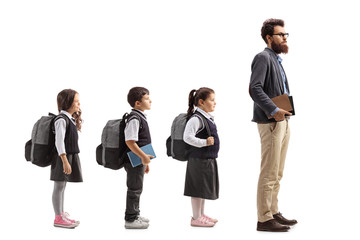 Fototapeta premium Schoolchildren waiting in line behing male teacher