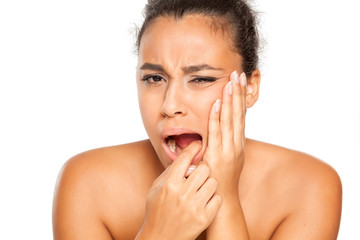 portrait of young dark-skinned woman with tooth ache on white background