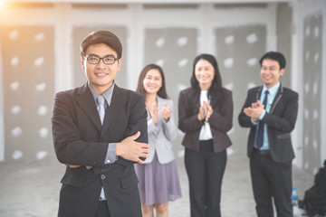 businessman portrait with employee clapping hands as background