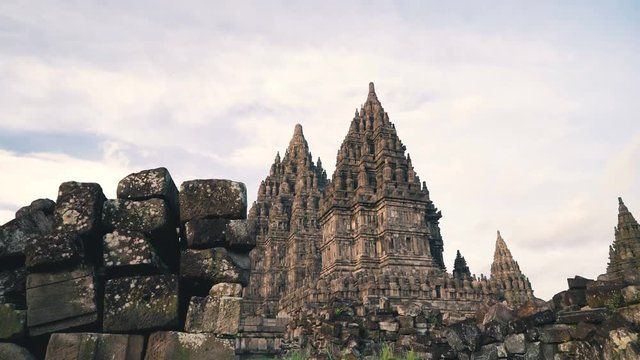 Prambanan temple towers stone brick piles in Jogjakarta, Indonesia at sunset, slide right