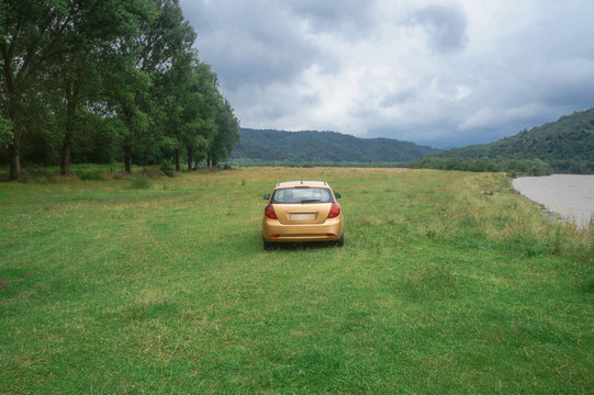 Car near a beautiful mountain river in cloudy weather in the european chati world. The flood of rain. Stock photo for design