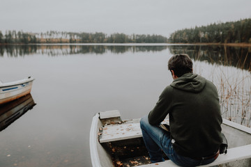 Einsamer Mann im Ruderboot an einem See im Herbst in Schweden / Lonesome Guy In Skiff At Lake During Indian Summer in Sweden