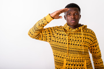 Studio shot of young black African man saluting against white ba