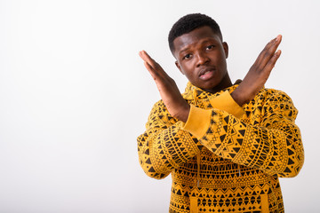 Studio shot of young black African man showing stop hand gesture