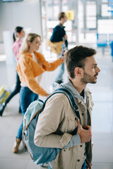 high angle view of young people with luggage looking away in airport terminal