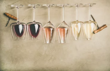 Afwasbaar Fotobehang Wijn Flat-lay van rode, rose en witte wijn in glazen in rij en kurkentrekkers over grijze betonnen achtergrond, bovenaanzicht, brede compositie. Wijnbar, wijnmakerij, wijndegustatieconcept