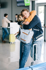 emotional young couple in love hugging in airport