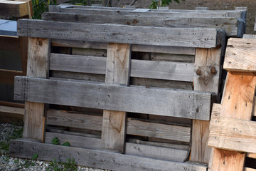 dark gray wooden pallets, weathered wooden pallets in a row stored outdoors