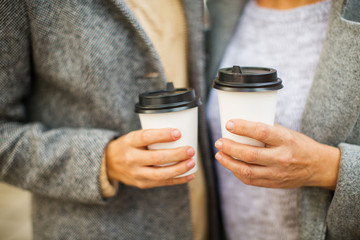 Hands with cups of coffee to go.