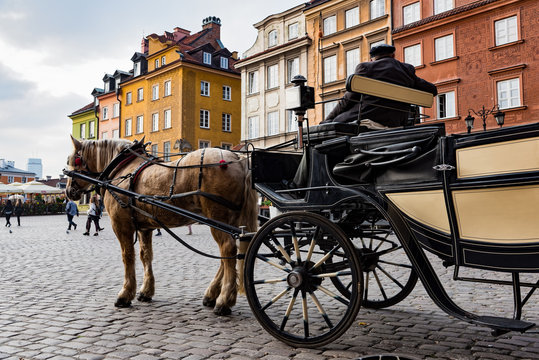 Fototapeta A man with a traditional carriage waits for tourists in the old town of Warsaw, Poland.