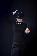 Actress in black hat and black suit holding cake