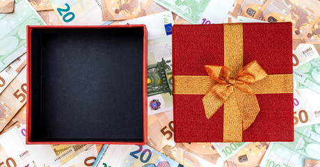 On a background of European money an empty open gift. Top view.