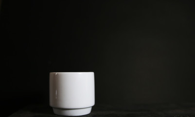 Close up black hot coffee cup on black wood table at cafe.dark scene.