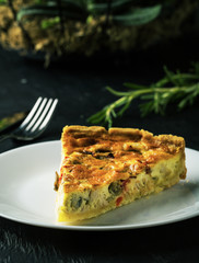 Delicious quiche on a plate on a dark background
