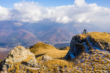 Aerial view. Epic shot of a mountain biker on top of the mountain looking down the valley. Aerial shot of mountain biker on the top looking at amazing view in the autumn. mountain bike. bycicle