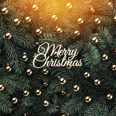 Winter background of fir branches. Adorned with golden baubles and Merry Christmas inscription. Christmas card. Top view. Xmas congratulation card with light effect.