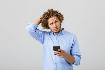 Portrait of a pensive confused young man with curly hair
