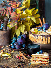Autumn composition with a slice of cream cake with chocolate and nuts, rustic