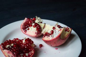 Pomegranate on a white plate. Close up.