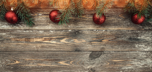 Old wood background with fir branches adorned with baubles. Space for text. Christmas card. Top...