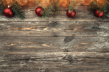 Old wood background with fir branches adorned with baubles. Space for text. Christmas card. Top...