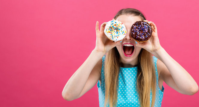Young woman with donuts on a pink background